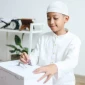 Ilustrasi seorang anak yang menabung uang hasil dari sedekah lebaran