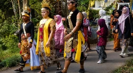 Peserta Kirab Pusaka mengenakan busana adat Banyumas mengiringi puncak Kamandaka Ciptarasa Festival 2026 dalam prosesi Sedekah Bumi Suran Tamansari.