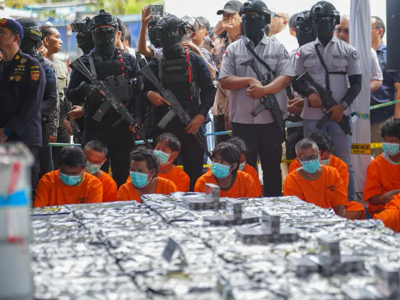 Petugas menunjukkan barang bukti cairan mengandung metamfetamin dan rokok ilegal yang diamankan dari kapal MV OCEAN PORTER di Perairan Karimun. (Foto: BNN RI).